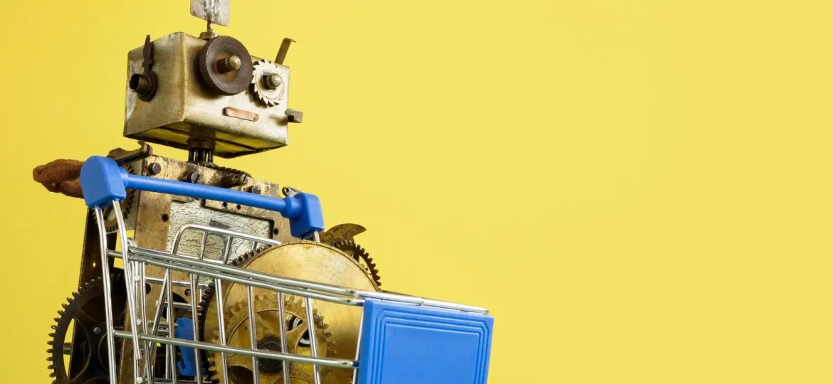 Ein Vintage-Roboter, der einen kleinen Einkaufswagen vor einem leuchtend gelben Hintergrund hält.